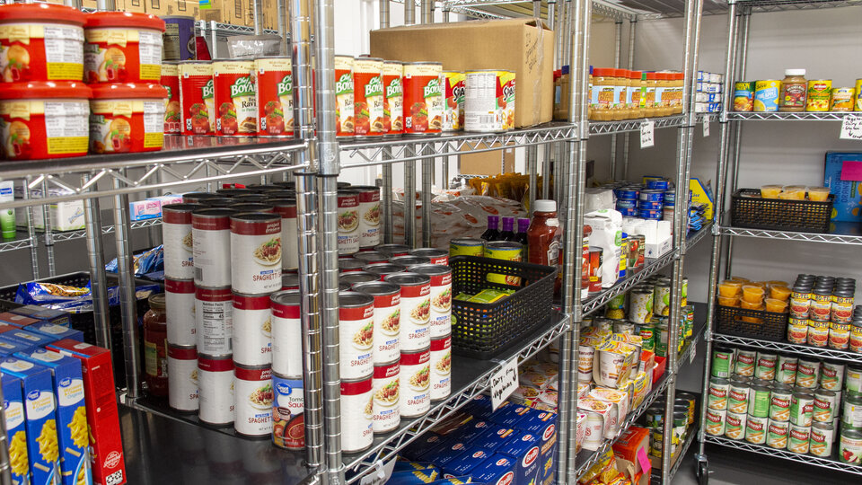 Canned and boxed food items neatly arranged on the shelves inside Husker Pantry. 